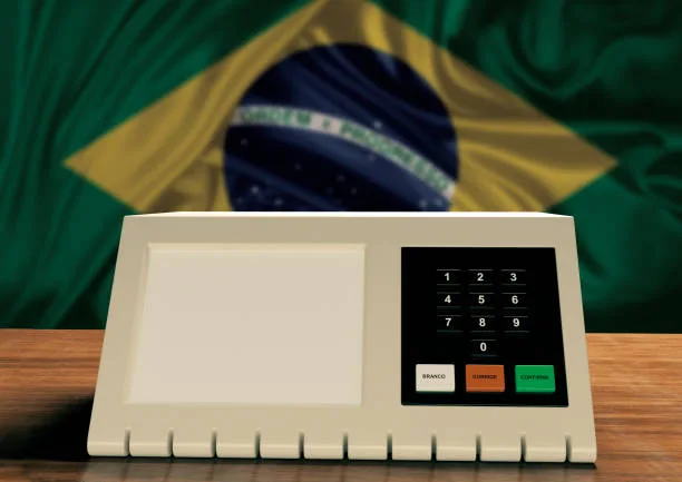 Urna eletrônica e bandeira com as cores do arco-iris representando pautas LGBTQIA+.