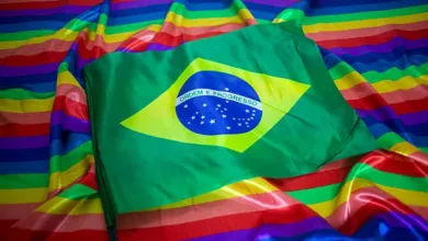 Urna eletrônica e bandeira com as cores do arco-íris representando candidaturas LGBT+